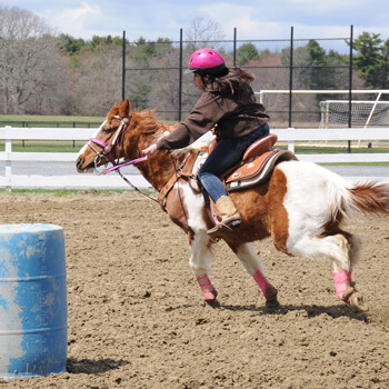 Teen riding horse in barrel race